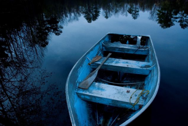 Gallery 1 - A boat in a lake, covered by an early morning shade of blue.